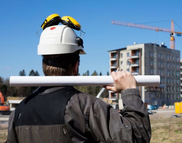 Construction worker in dirty overalls and a white helmet in Finl