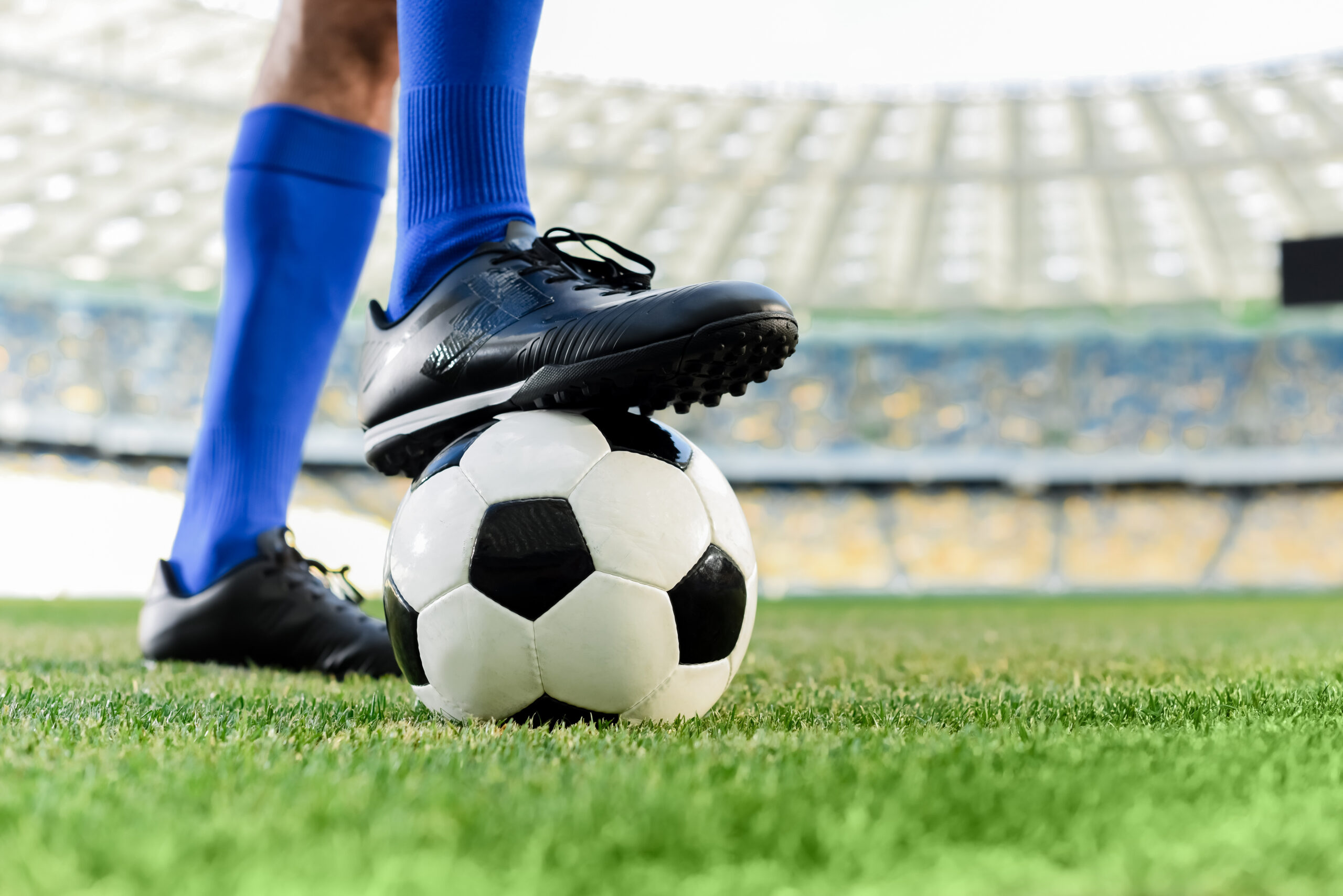 legs of professional soccer player in blue socks and soccer shoe